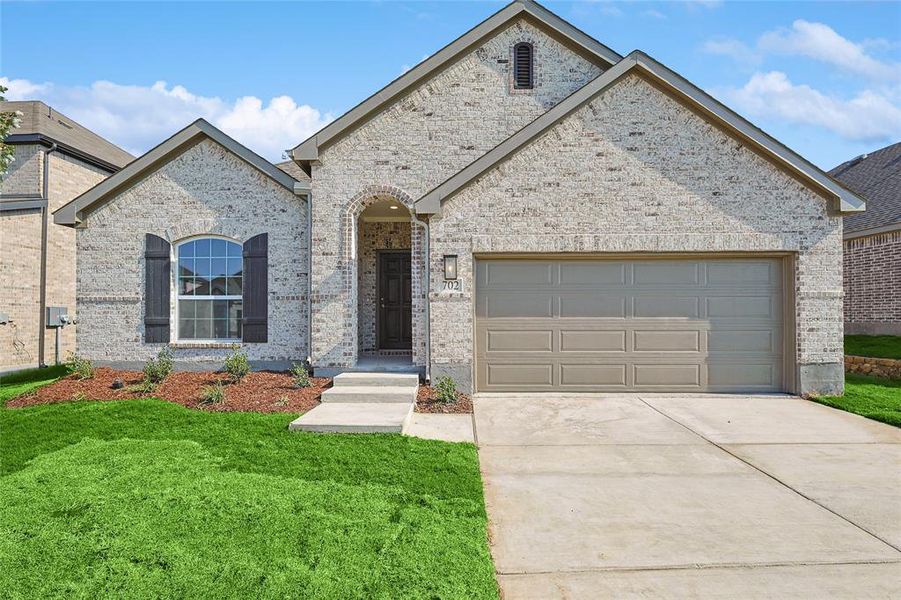 View of front of house featuring a garage and a front lawn