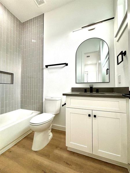 This photo showcases a magnificent contemporary bathroom accentuated by sleek lighting fixtures and black bathroom accessories.