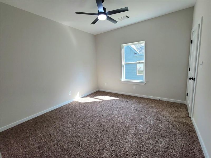 Carpeted empty room with ceiling fan