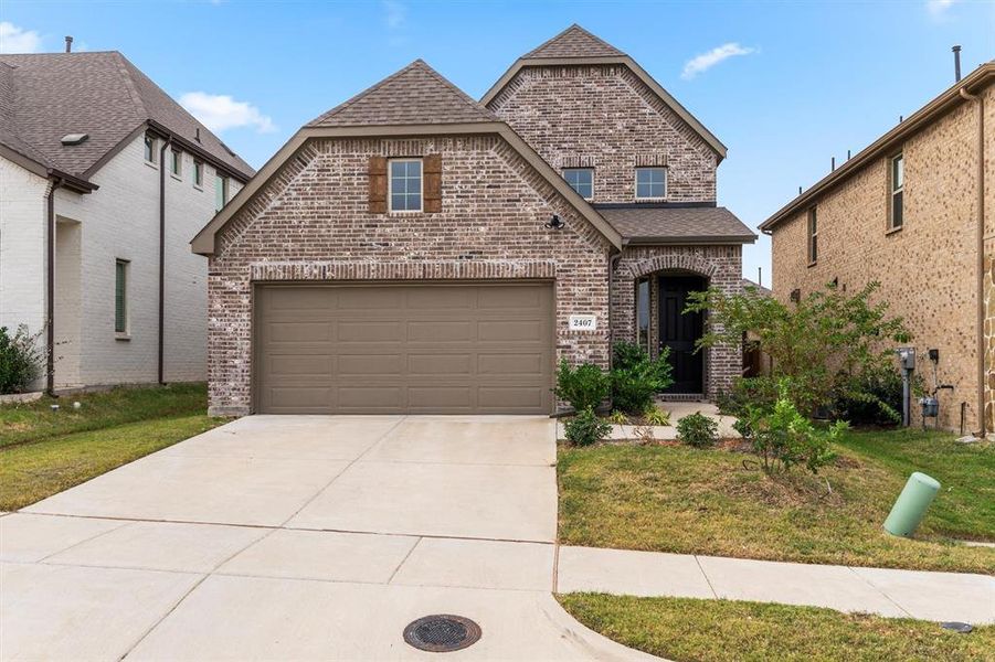 View of property featuring a front yard and a garage