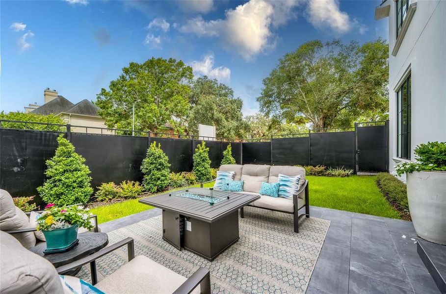 This perspective of the large yard highlights the stone patio, electric awning with smart features, and plenty of room for a pool!