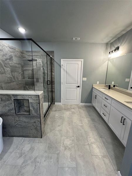 Bathroom featuring vanity and a shower with shower door