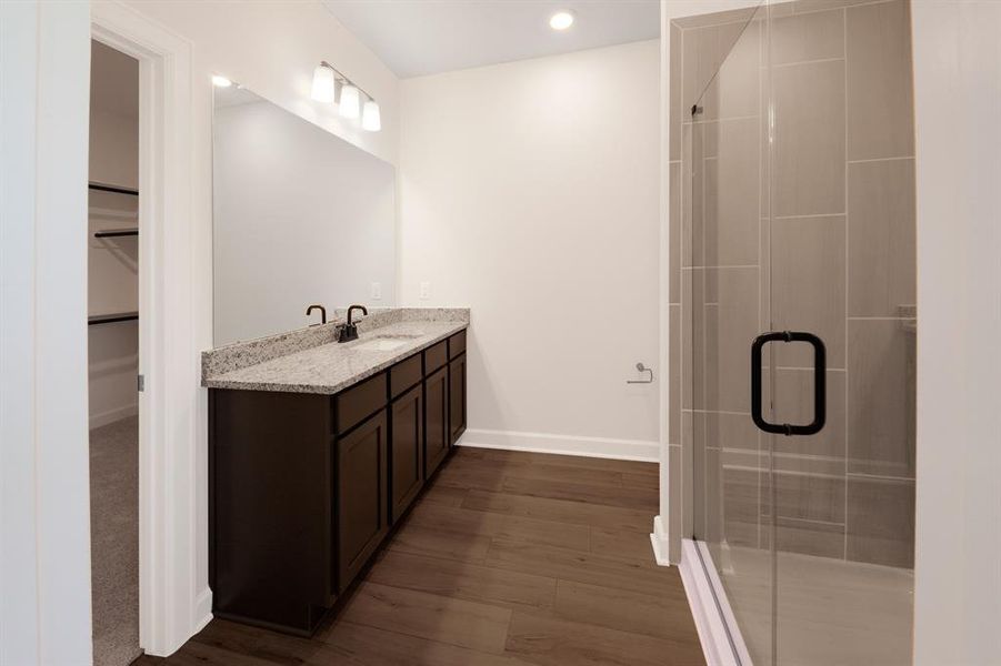 Welcome to the en-suite bathroom, featuring a chic vanity with ample storage space and a large shower for added luxury.