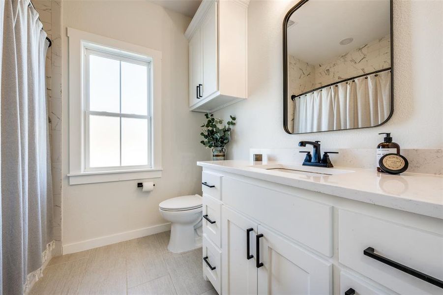 Bathroom with tile flooring, toilet, and oversized vanity