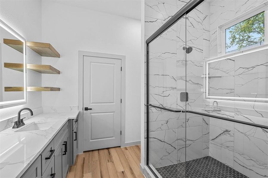 Bathroom with walk in shower, vanity, and hardwood / wood-style floors