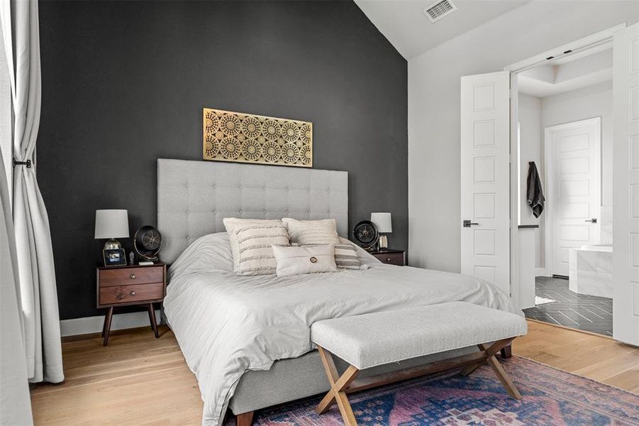 Bedroom featuring lofted ceiling and light wood-type flooring