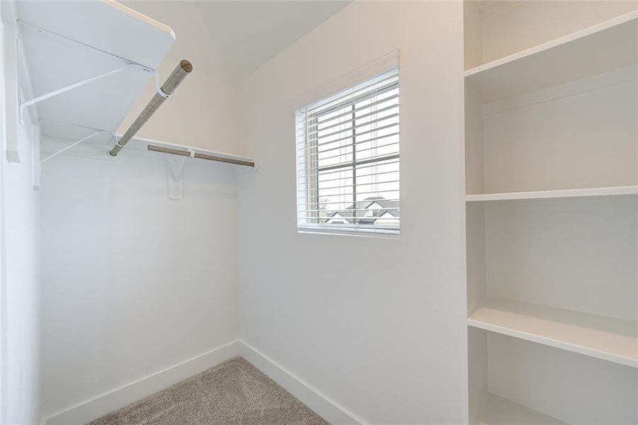 Secondary bedroom closet with shelving units.