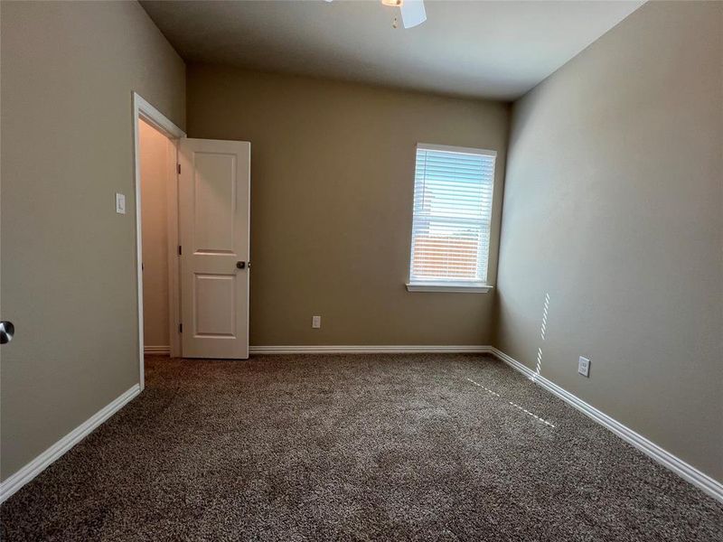 Carpeted spare room featuring ceiling fan