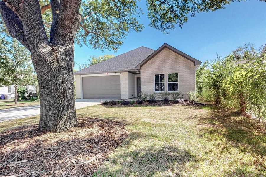 View of front of property featuring a garage and a front lawn