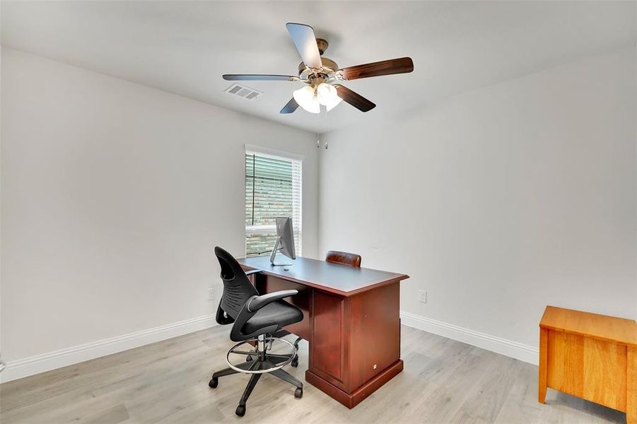 Office space with ceiling fan and light hardwood / wood-style flooring