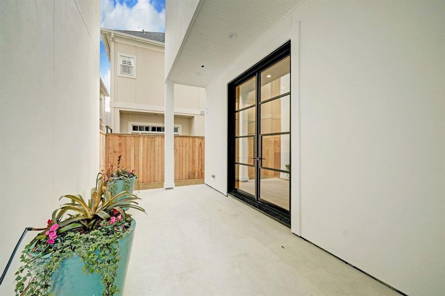 These contemporary glass doors open to this lovely patio space with plenty of room for seating , relaxing or dining.