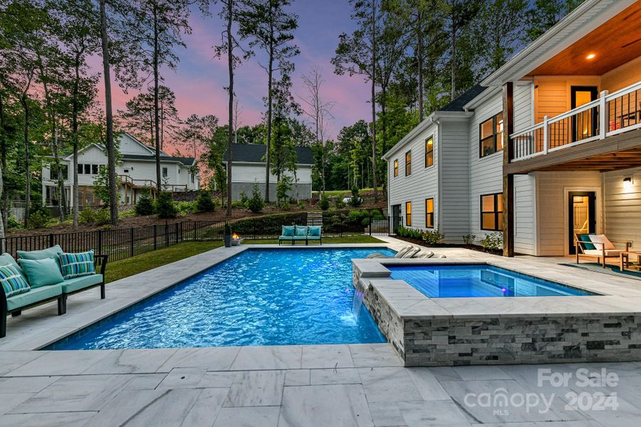 Outdoor Oasis features covered patio, spectacular, salt water pool/spa with sun bathing ledge & built in fire pits & plenty of pool decking for lounging!