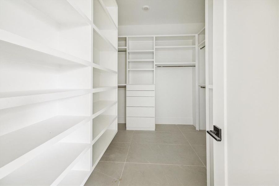 A primary closet anyone can appreciate with built ins and additional drawer storage. Closet connects to full size utility room.