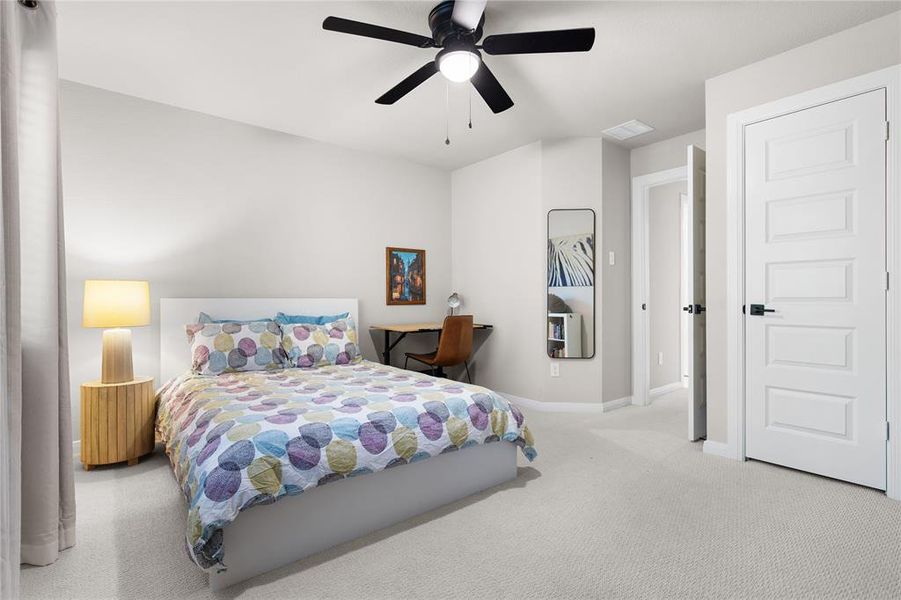 Bedroom with ceiling fan and light carpet