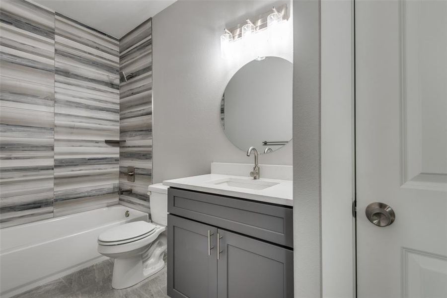 Bathroom features cabinets with hardware & combination shower and tub.