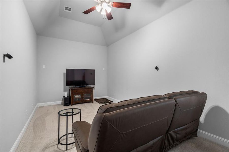 Media room with vaulted ceiling and ceiling fan