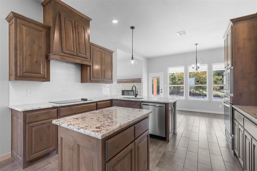 Kitchen featuring a center island, stainless steel appliances, kitchen peninsula, and pendant lighting