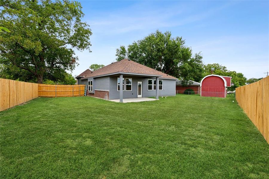 View of yard with a storage unit and a patio