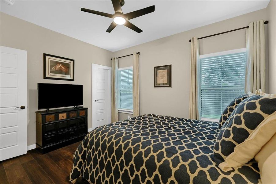 Bedroom with dark hardwood / wood-style floors and ceiling fan