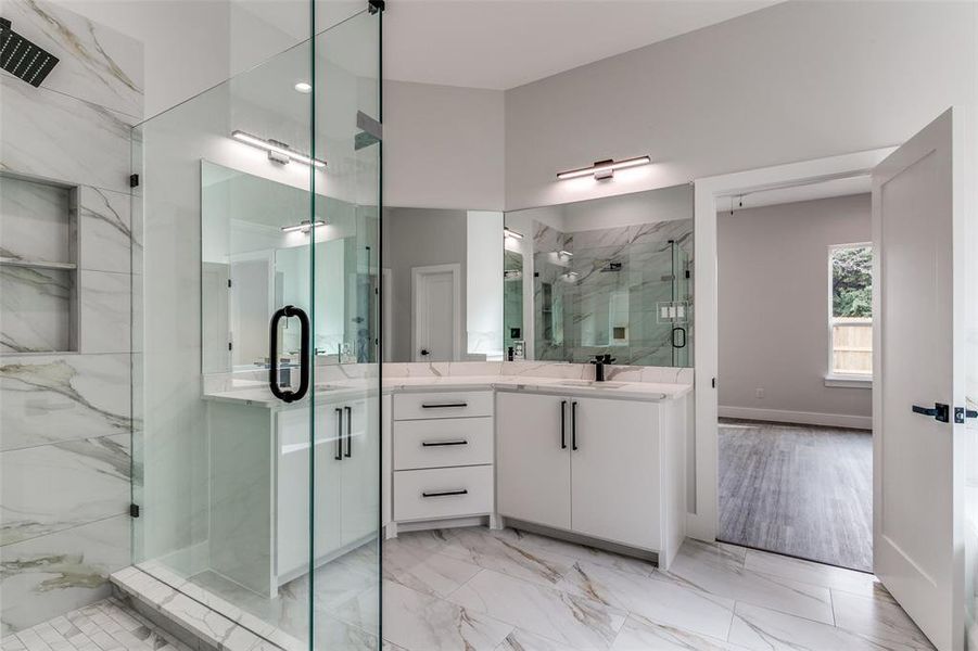 Bathroom with a shower with door, tile flooring, and vanity with extensive cabinet space