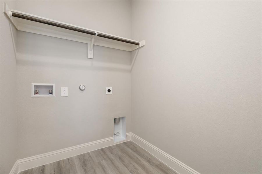 Laundry area with hookup for a gas dryer, hardwood / wood-style floors, washer hookup, and electric dryer hookup