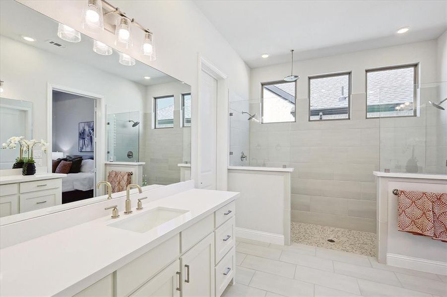 Bathroom featuring vanity, plenty of natural light, and tiled shower