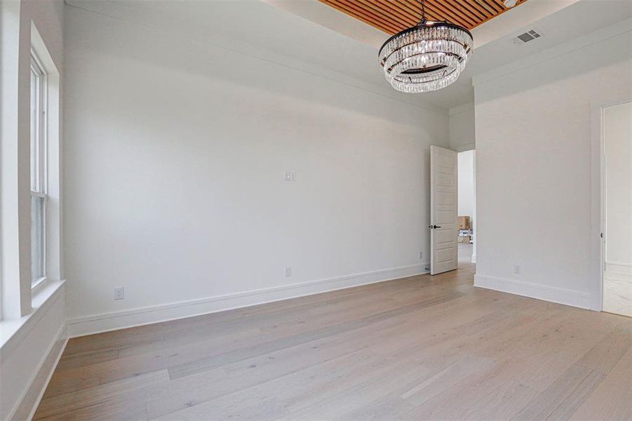 Unfurnished room featuring a chandelier, wood ceiling, and light wood-type flooring