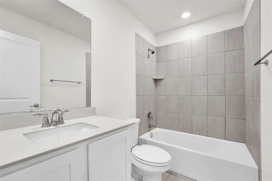 Full bathroom featuring tiled shower / bath combo, tile flooring, toilet, and oversized vanity