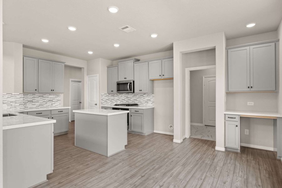 The kitchen is open to the dining area featuring a built in desk