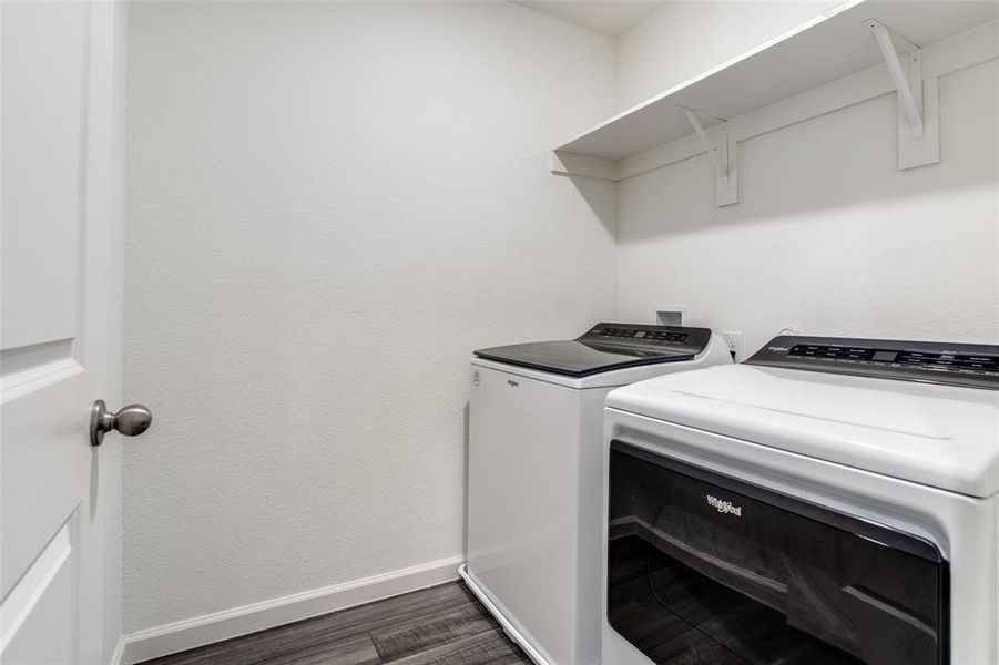 Laundry room featuring wood-type flooring and separate washer and dryer