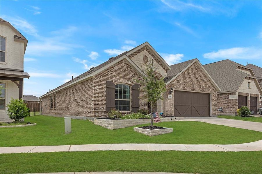 View of front of property featuring a garage and a front yard