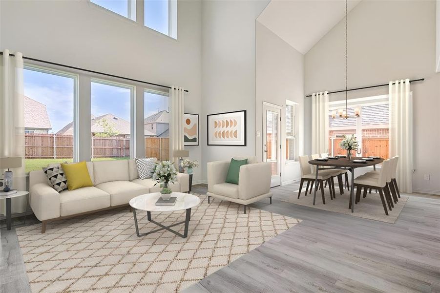 Living room with high vaulted ceiling, light hardwood / wood-style floors, plenty of natural light, and a notable chandelier