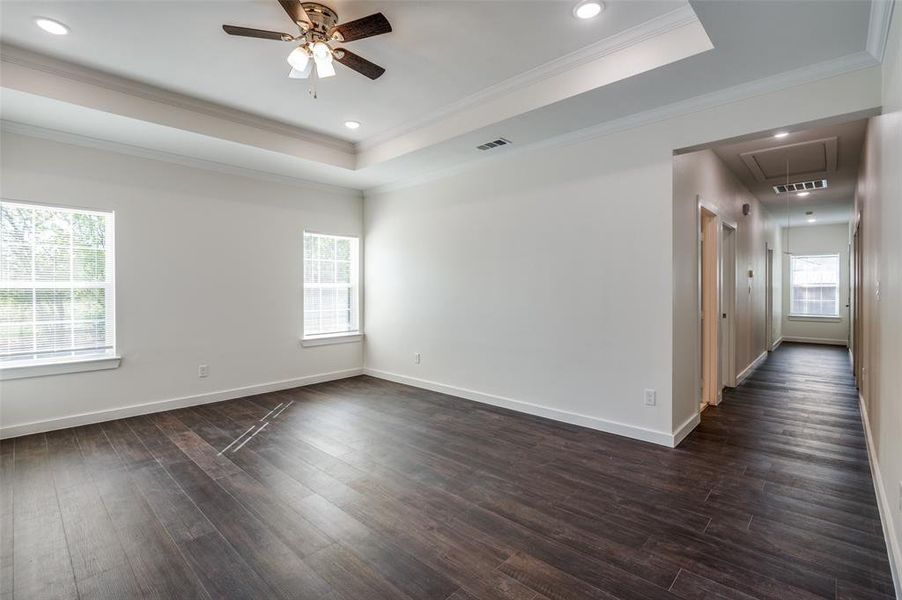 Unfurnished room featuring crown molding, ceiling fan, a tray ceiling, and dark hardwood / wood-style flooring