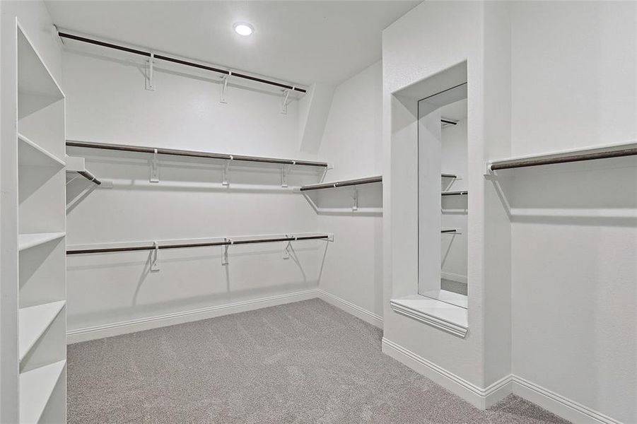 Walk in closet featuring light colored carpet