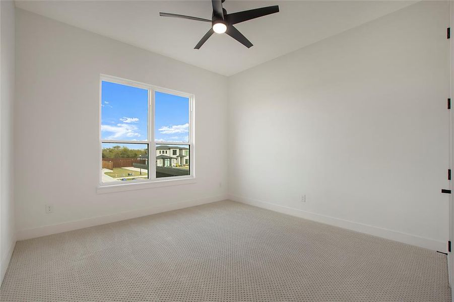 Carpeted empty room with ceiling fan