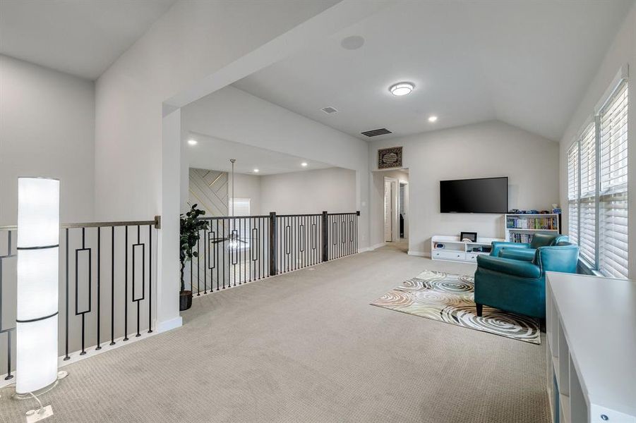 Sitting room featuring light carpet and lofted ceiling