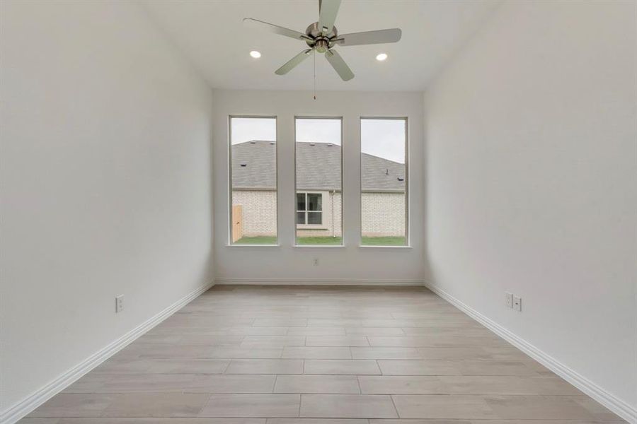 Unfurnished room featuring plenty of natural light, ceiling fan, and light wood-type flooring