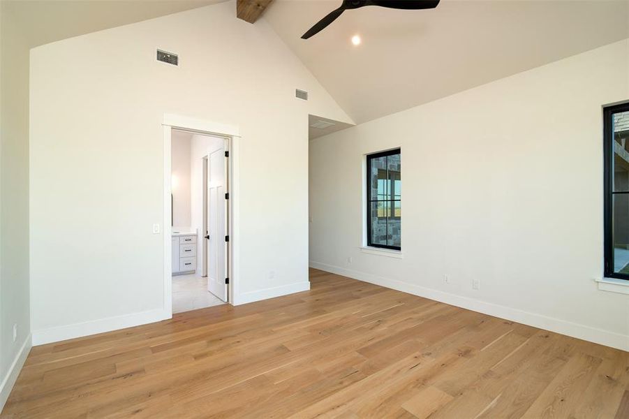 Spare room with ceiling fan, high vaulted ceiling, beamed ceiling, and light hardwood / wood-style flooring