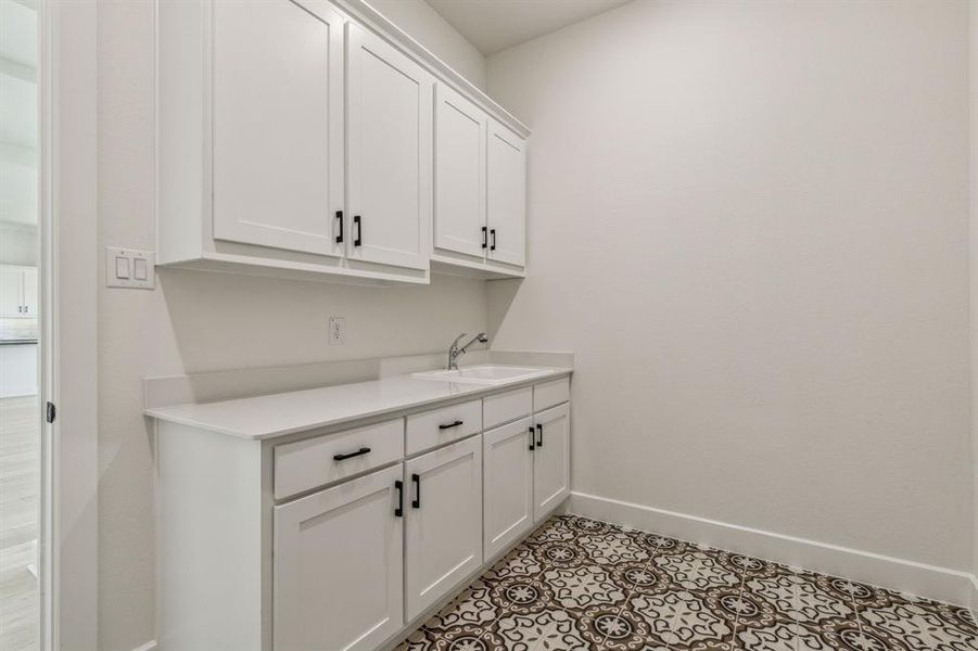 Laundry room with sink and light tile patterned flooring