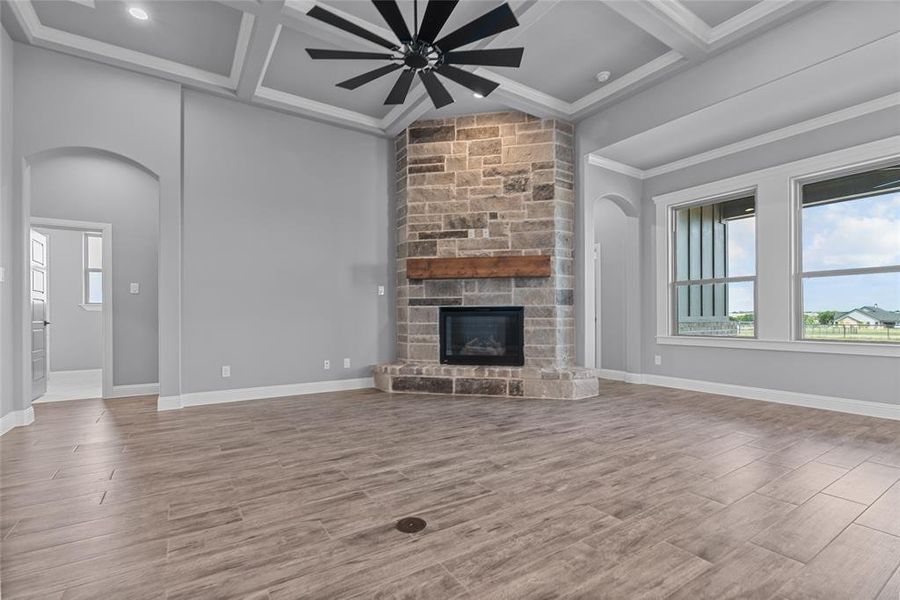 Unfurnished living room featuring wood-type flooring, coffered ceiling, and ceiling fan