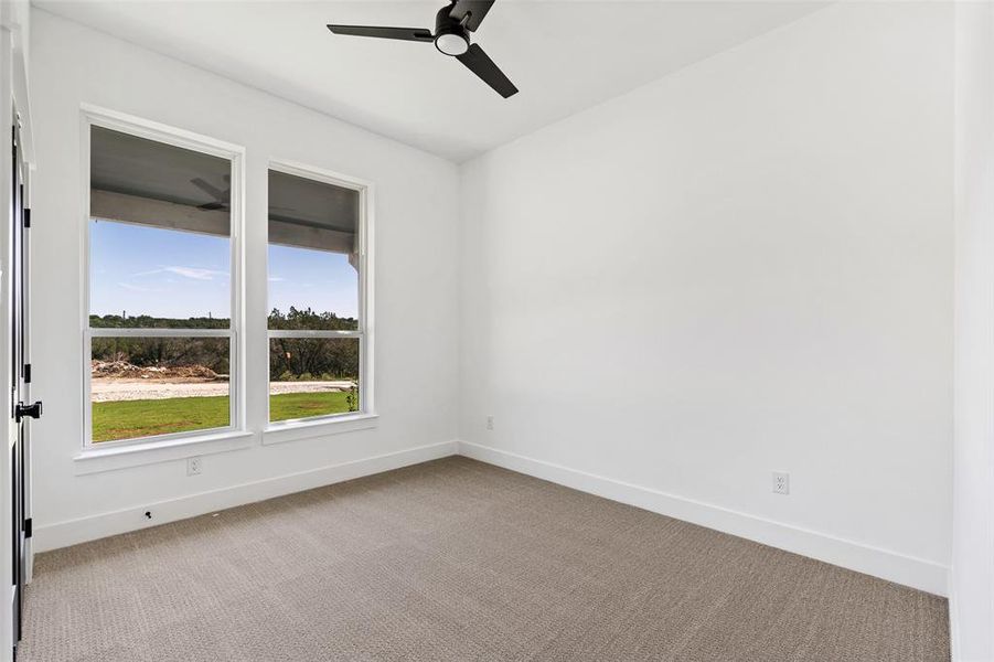 Carpeted empty room with ceiling fan