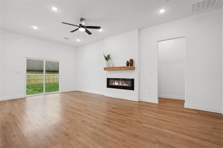 Unfurnished living room featuring ceiling fan and light hardwood / wood-style flooring