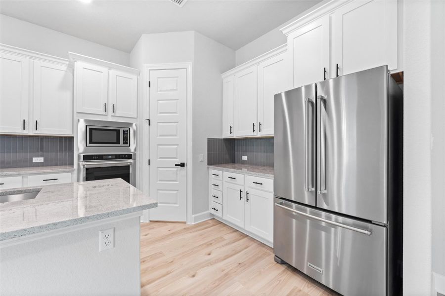 The kitchen comes equipped with upgraded, Kitchen Aid stainless steel appliances, a gorgeous center island, and French-door refrigerator.