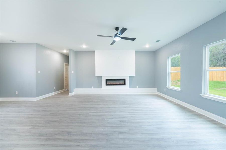 Unfurnished living room featuring light hardwood / wood-style flooring and ceiling fan