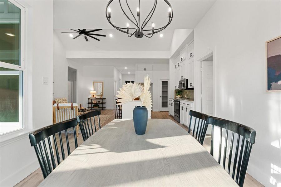 Dining room featuring ceiling fan, light hardwood / wood-style flooring, and high vaulted ceiling