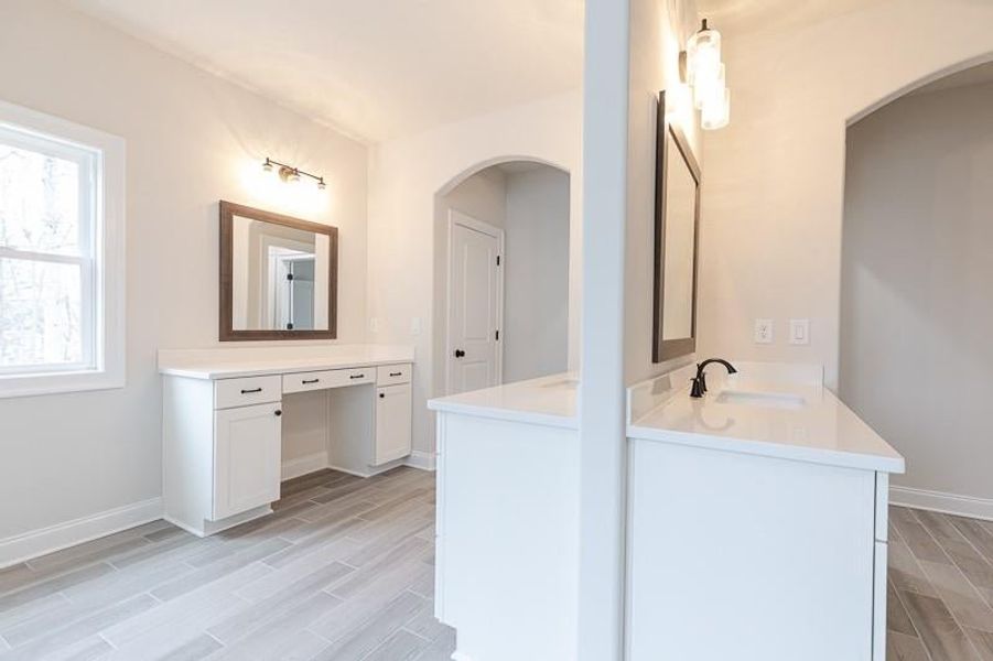 Owner's bath is sure to impress, with a fabulous entryway and dual sinks.  Photo not actual home, but previously built Mansfield plan.