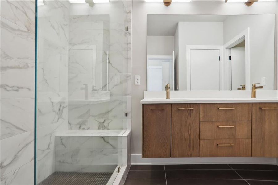 Sleek master bath design with spacious shower including shower bench, double vanity and additional closet.