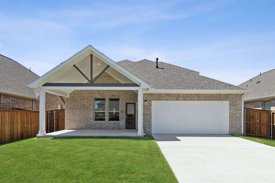 View of front of property featuring a garage and a front yard