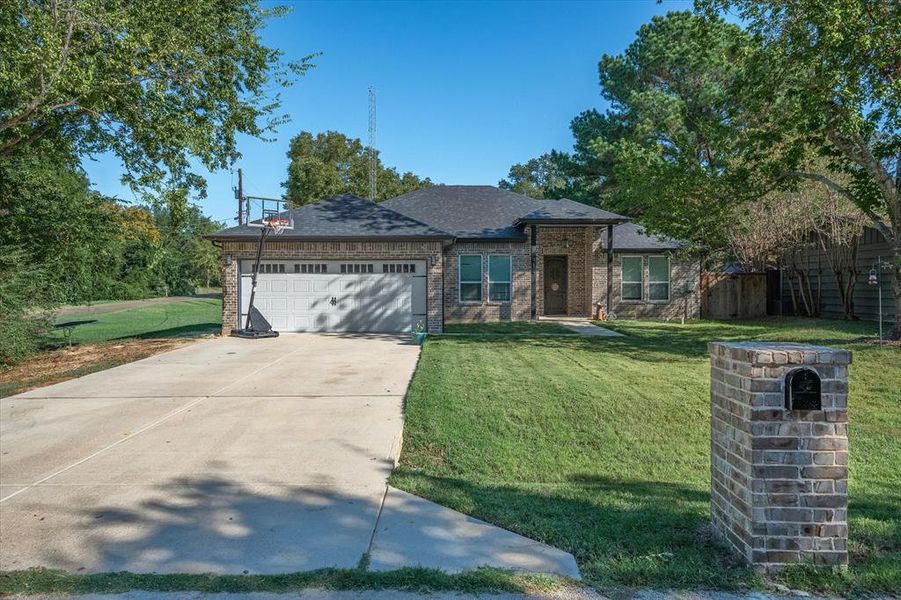 View of front of home with a garage and a front lawn