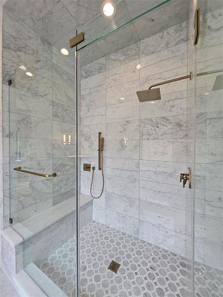 Floor to ceiling polished marble walls. Fixed & hand held high-end shower fixtures